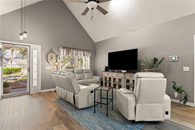 living room with ceiling fan, baseboards, and wood finished floors