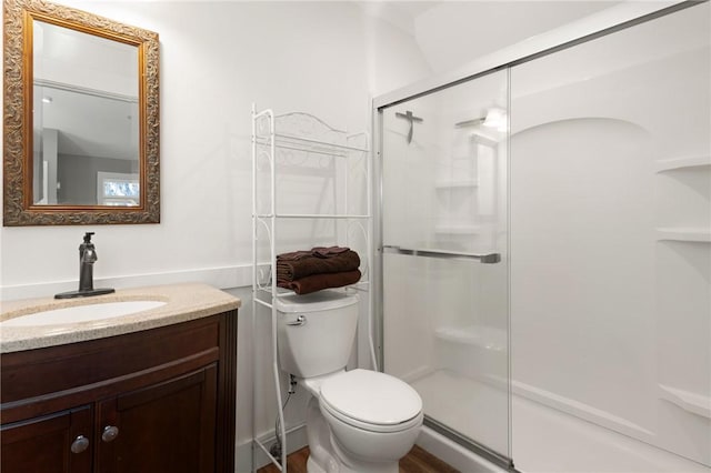 full bathroom with a shower stall, toilet, and vanity