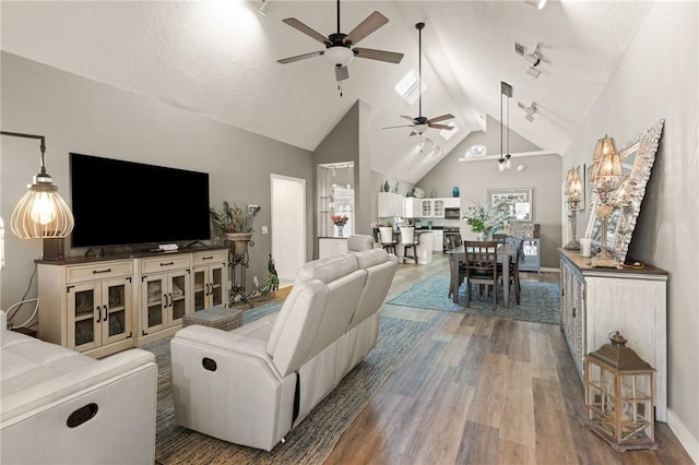 living area featuring high vaulted ceiling, a textured ceiling, baseboards, and wood finished floors