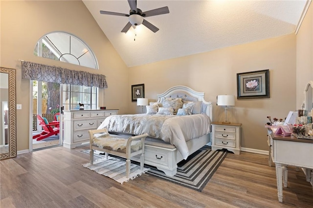 bedroom with high vaulted ceiling, access to outside, baseboards, and wood finished floors