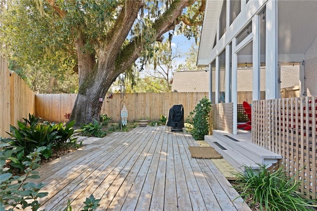 wooden terrace with a fenced backyard