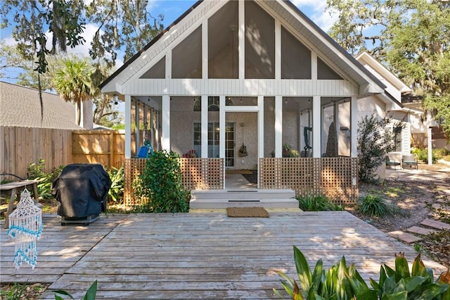 back of property with a sunroom, fence, and a wooden deck