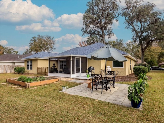 rear view of house with a yard, a patio, and a sunroom