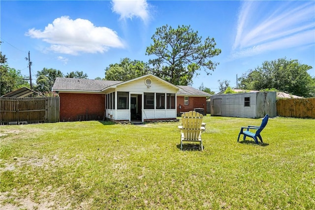 125 Enterprise St, Brunswick, GA 31525 - rear view of property with a sunroom, a fenced backyard, a storage unit, and brick siding