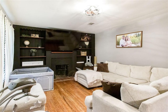 300 Community Dr, Waycross, GA 31501 - living room with wood finished floors, a fireplace, and built in features
