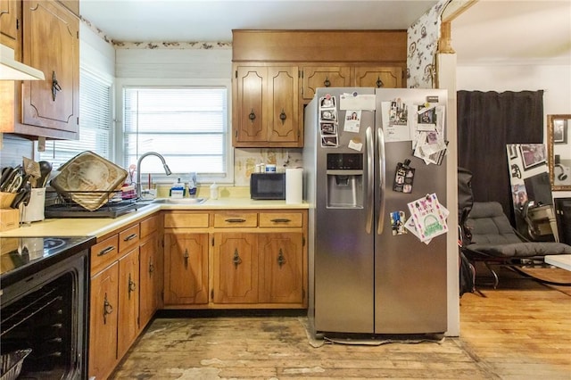 300 Community Dr, Waycross, GA 31501 - kitchen featuring stainless steel fridge with ice dispenser, a sink, light wood-style floors, under cabinet range hood, and light countertops