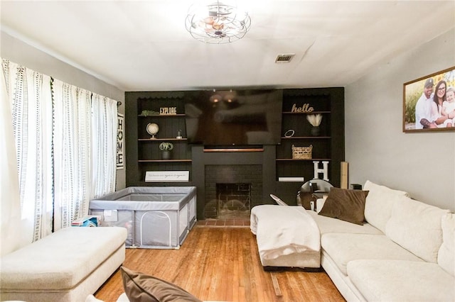300 Community Dr, Waycross, GA 31501 - living room featuring a fireplace, light wood-style flooring, and built in shelves