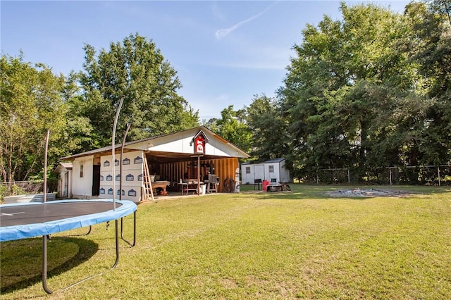 300 Community Dr, Waycross, GA 31501 - view of yard with a trampoline, an outdoor structure, and view of wooded area