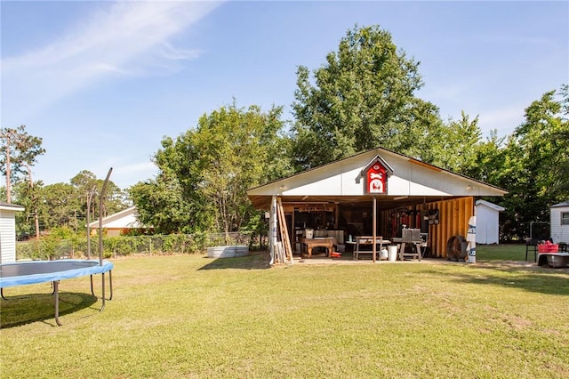 300 Community Dr, Waycross, GA 31501 - view of grassy yard with a trampoline, an outbuilding, and a pole building