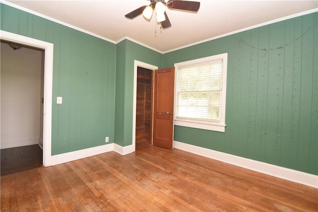 2108 Darling Ave, Waycross, GA 31501 - unfurnished bedroom with wood finished floors, crown molding, baseboards, ceiling fan, and wood walls