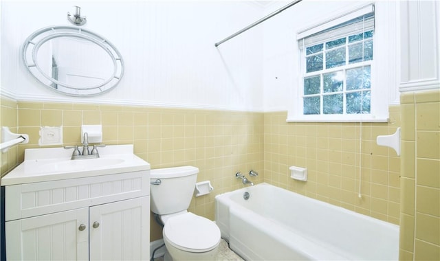 2108 Darling Ave, Waycross, GA 31501 - bathroom with a bath, toilet, vanity, tile walls, and a wainscoted wall