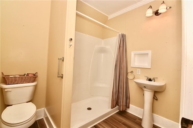 2108 Darling Ave, Waycross, GA 31501 - bathroom with ornamental molding, wood finished floors, toilet, baseboards, and a stall shower