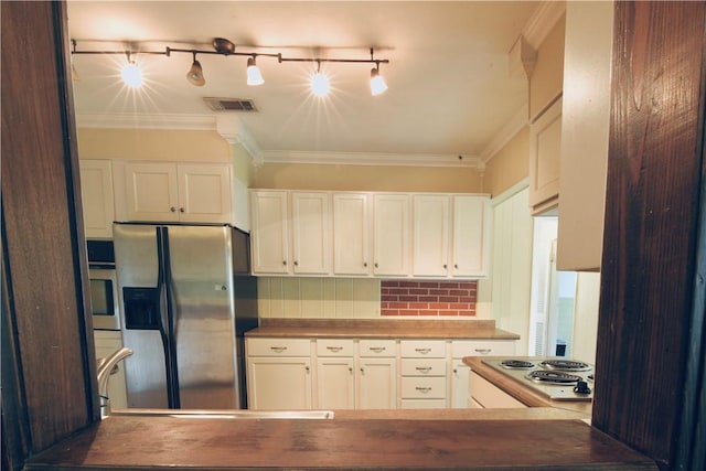 2108 Darling Ave, Waycross, GA 31501 - kitchen with stainless steel appliances, ornamental molding, white cabinets, and dark countertops