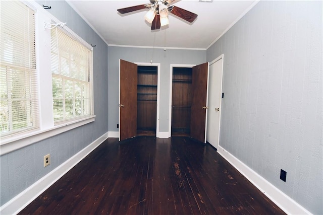 2108 Darling Ave, Waycross, GA 31501 - unfurnished bedroom featuring hardwood / wood-style flooring, ornamental molding, baseboards, two closets, and a ceiling fan