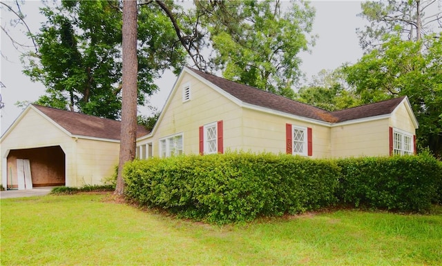2108 Darling Ave, Waycross, GA 31501 - view of side of home with an outdoor structure, a yard, a shingled roof, and a detached carport