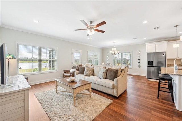 139 Allie Loop, Brunswick, GA 31525 - living room with a ceiling fan, a chandelier, dark wood-style flooring, recessed lighting, and ornamental molding