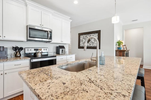 139 Allie Loop, Brunswick, GA 31525 - kitchen featuring stainless steel appliances, a kitchen island with sink, ornamental molding, dark wood-style floors, and white cabinetry