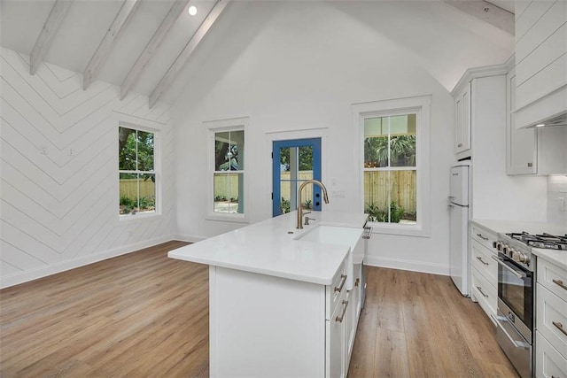 247 Circle Dr, Saint Simons Island, GA 31522 - kitchen with gas stove, freestanding refrigerator, an island with sink, healthy amount of natural light, and recessed lighting