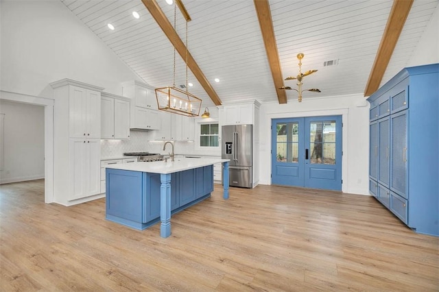 247 Circle Dr, Saint Simons Island, GA 31522 - kitchen featuring high end fridge, a chandelier, light countertops, blue cabinetry, and high vaulted ceiling