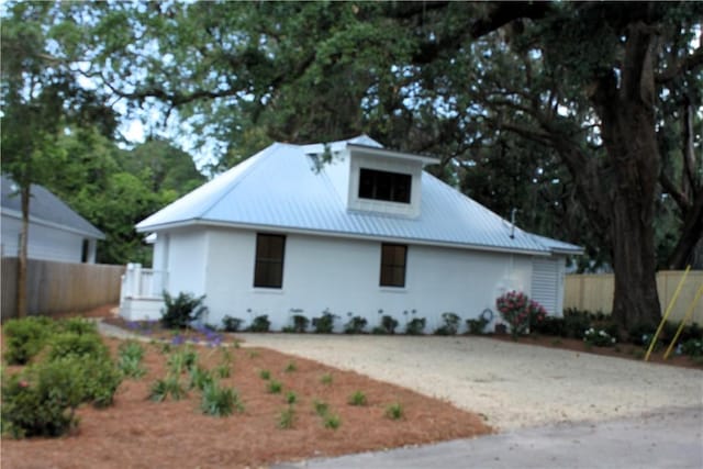 247 Circle Dr, Saint Simons Island, GA 31522 - view of front of property with metal roof and stucco siding