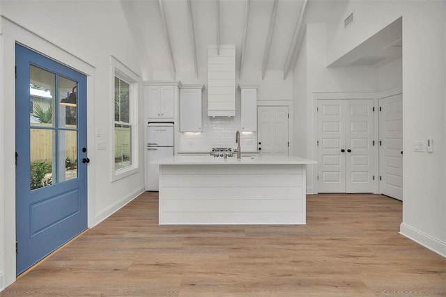 247 Circle Dr, Saint Simons Island, GA 31522 - kitchen with white cabinets, light countertops, a center island with sink, and healthy amount of natural light