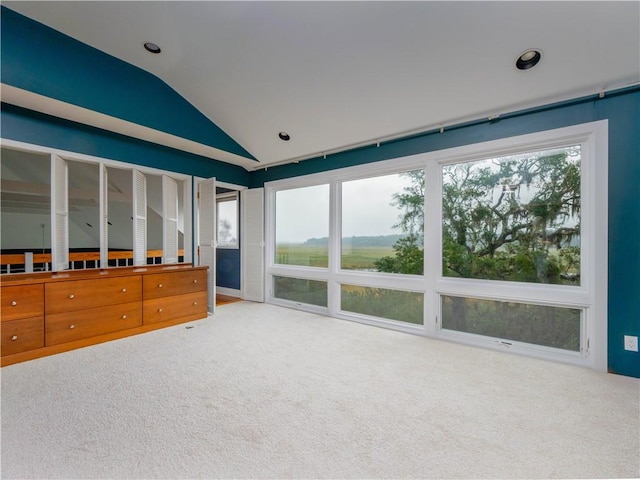 unfurnished living room with light colored carpet and lofted ceiling