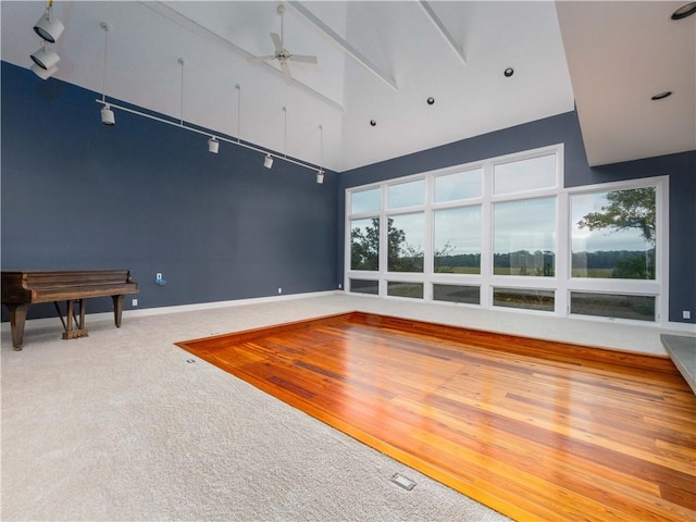 interior space featuring carpet, high vaulted ceiling, and ceiling fan