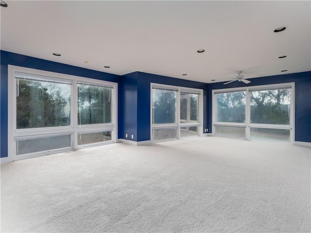 unfurnished living room featuring carpet flooring and ceiling fan