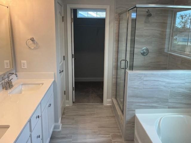 bathroom featuring separate shower and tub and vanity