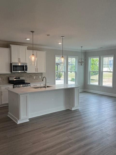 kitchen with a center island with sink, white cabinets, dark hardwood / wood-style floors, and appliances with stainless steel finishes