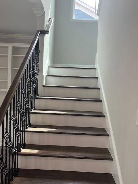 stairway with crown molding and hardwood / wood-style floors