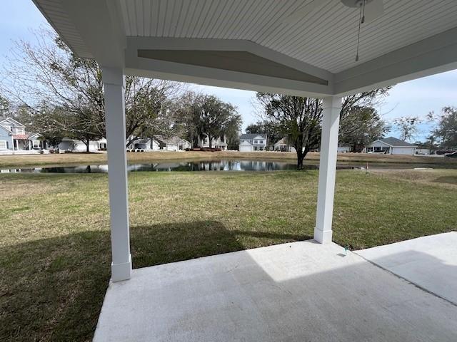 view of yard with a water view and a patio