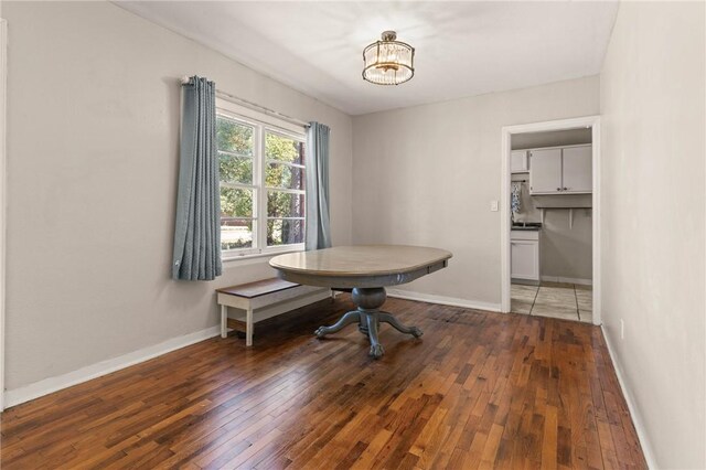 dining space featuring an inviting chandelier, wood-type flooring, and baseboards