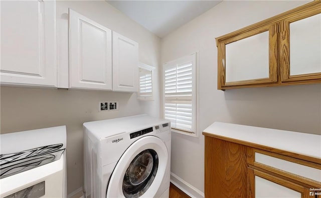 laundry area featuring cabinets and washer / dryer