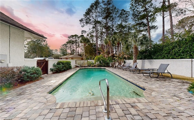 pool at dusk with a patio