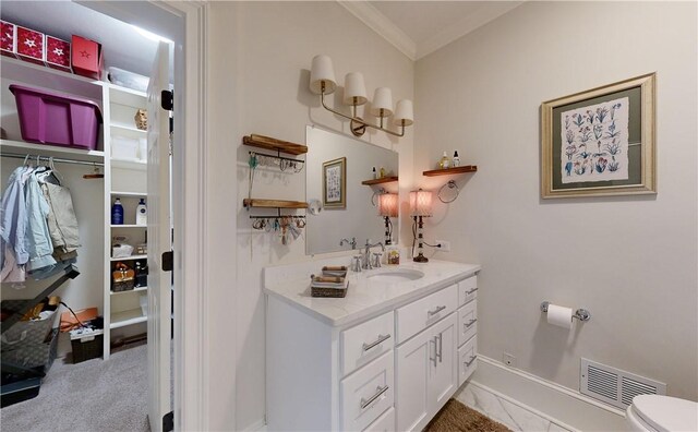 bathroom with vanity, ornamental molding, and toilet