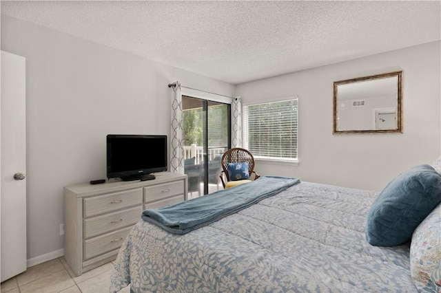 tiled bedroom featuring a textured ceiling