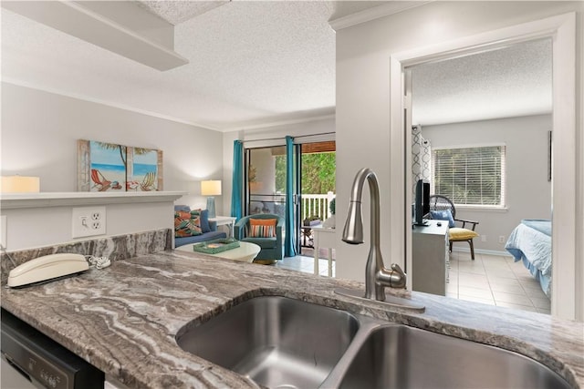 kitchen with a textured ceiling, stainless steel dishwasher, ornamental molding, and sink