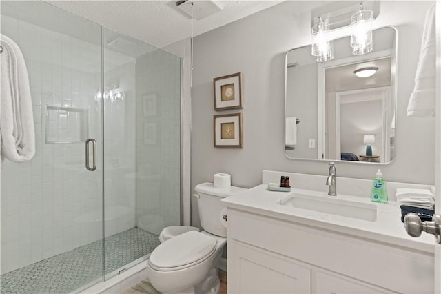 bathroom featuring a shower with door, vanity, a textured ceiling, and toilet