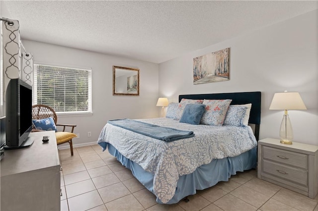 bedroom featuring light tile patterned floors and a textured ceiling