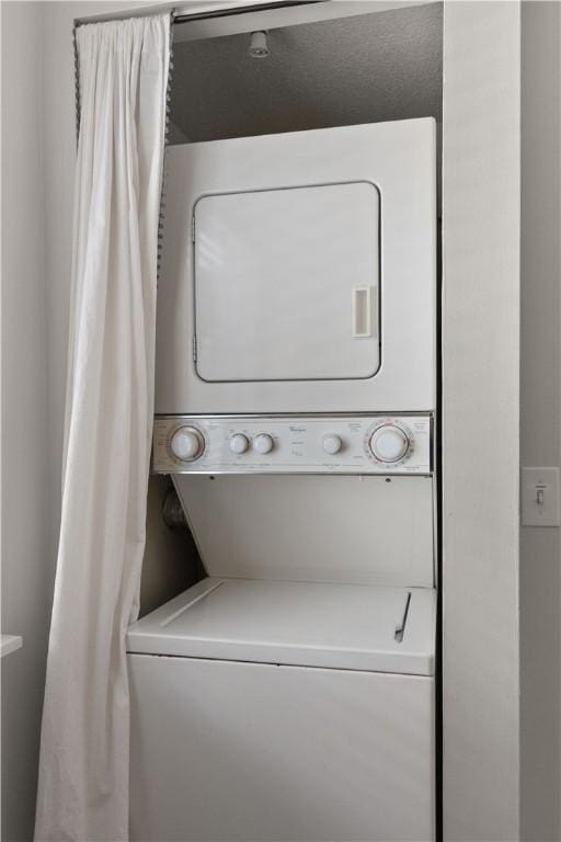 clothes washing area featuring stacked washer / dryer