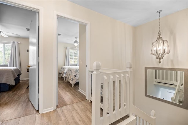 850 Mallery St Unit 3M, Saint Simons Island, GA 31522 - hallway featuring light wood-style flooring, a chandelier, and an upstairs landing