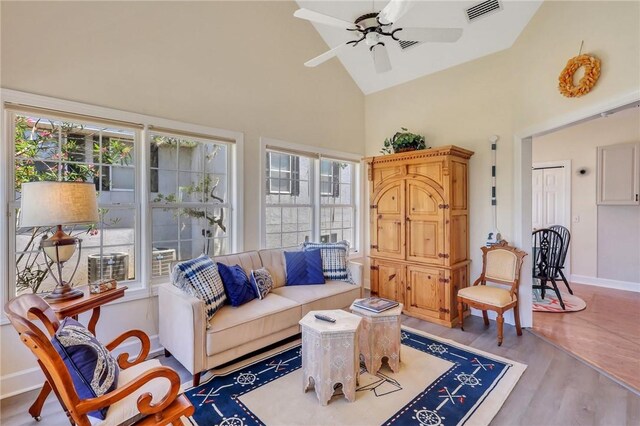 living area featuring baseboards, visible vents, a ceiling fan, wood finished floors, and high vaulted ceiling