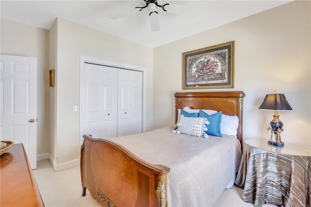 bedroom with ceiling fan, a closet, light colored carpet, and baseboards