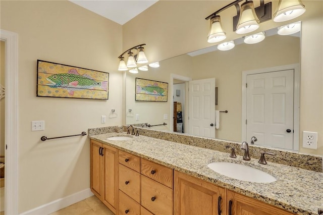 bathroom with double vanity, tile patterned flooring, a sink, and baseboards