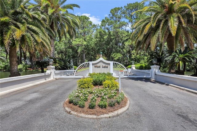 view of street featuring a gate, curbs, and a gated entry