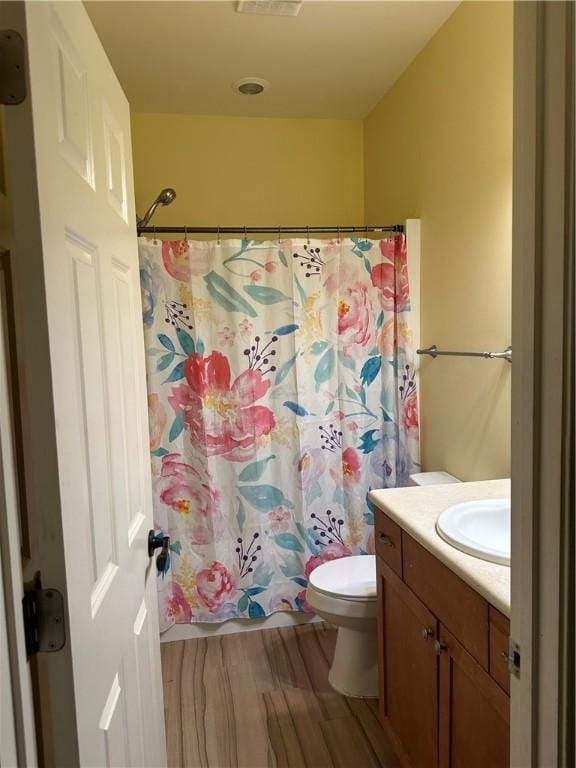 116 Bartram Trl, Blackshear, GA 31516 - full bathroom featuring vanity, toilet, wood finished floors, and a shower with curtain