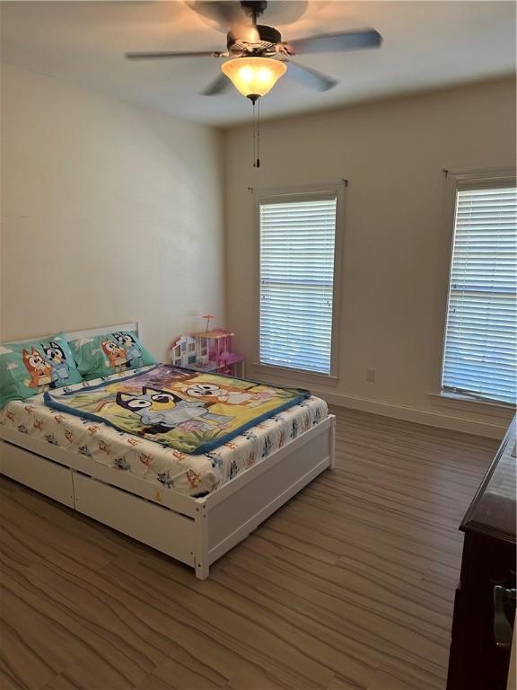 116 Bartram Trl, Blackshear, GA 31516 - bedroom with multiple windows, light wood-style floors, baseboards, and a ceiling fan