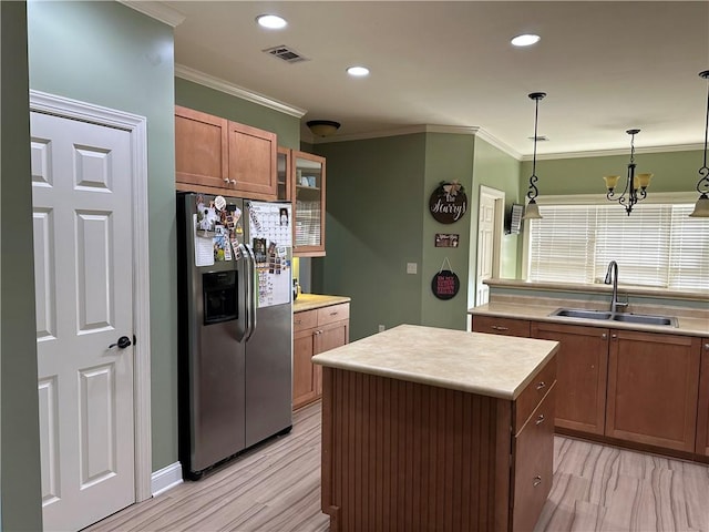 116 Bartram Trl, Blackshear, GA 31516 - kitchen featuring stainless steel fridge with ice dispenser, a sink, brown cabinetry, crown molding, and light countertops