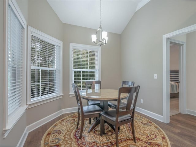 dining room with vaulted ceiling, wood-type flooring, and a chandelier